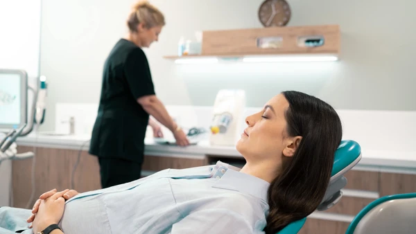 A middle-aged lady reclining on a dentist chair